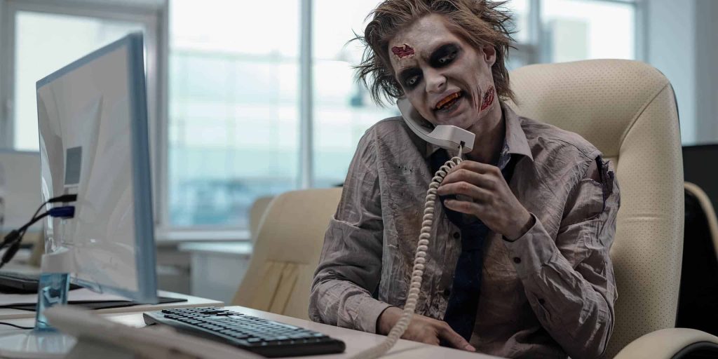 Zombie,Businessman,With,Phone,Receiver,Between,His,Shoulder,And,Cheek